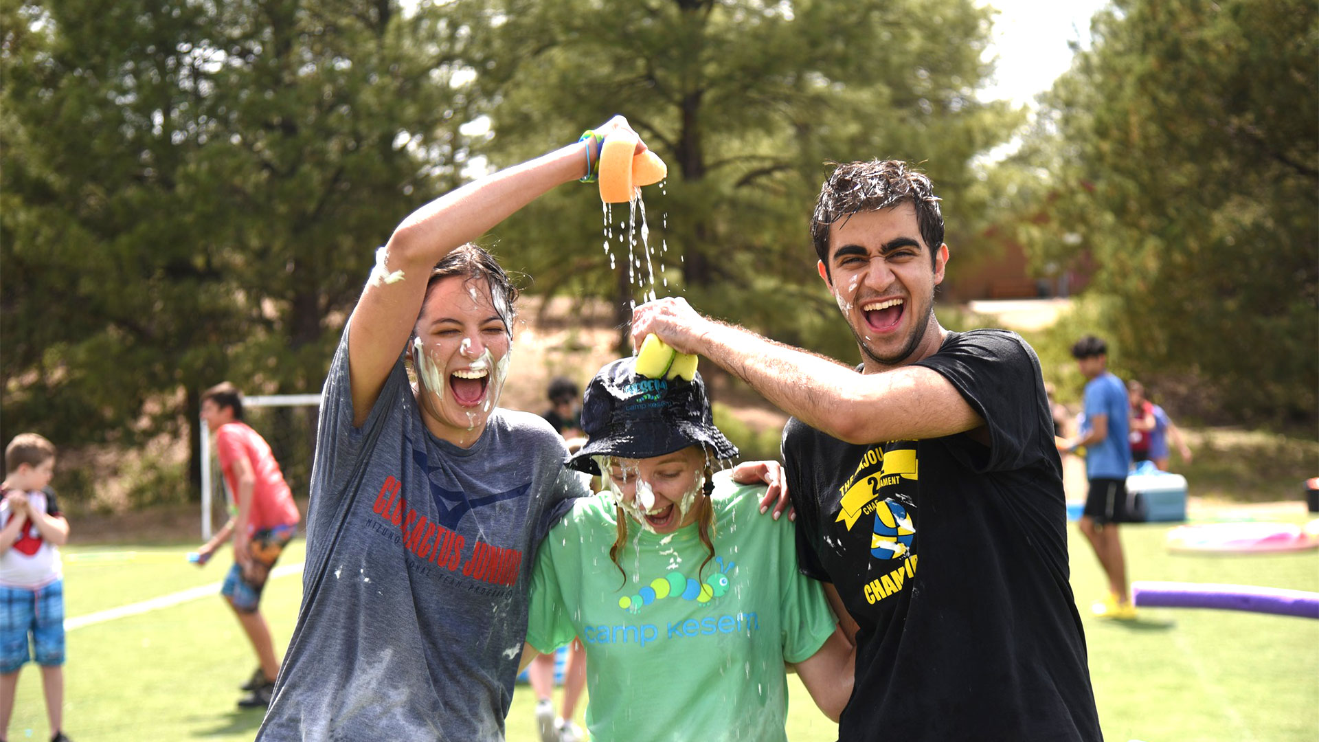 young people laughing and having a shaving cream fight on the field